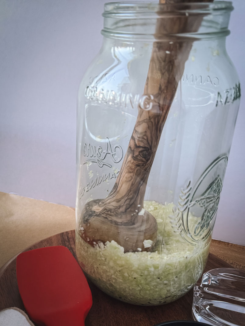 quick sauerkraut in a ball jar with wood pounder