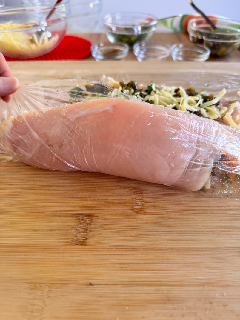 rolling a chicken breast for a healthy chicken dinner