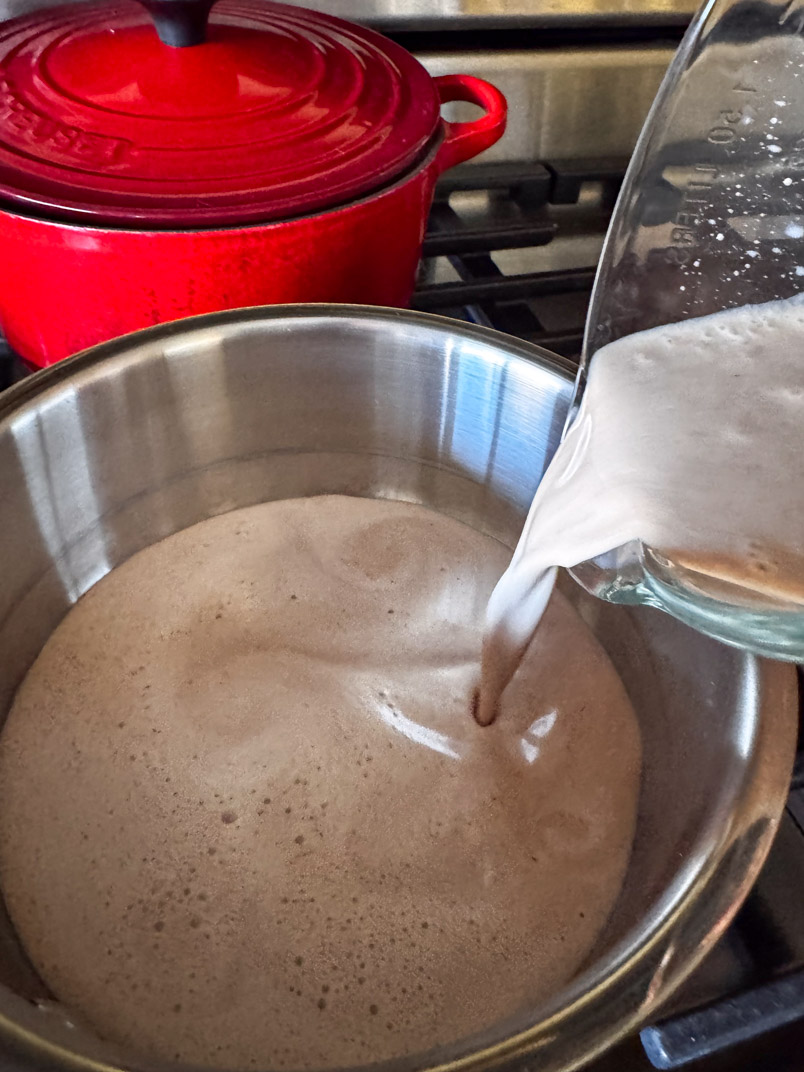 pouring hot date milk into the pan