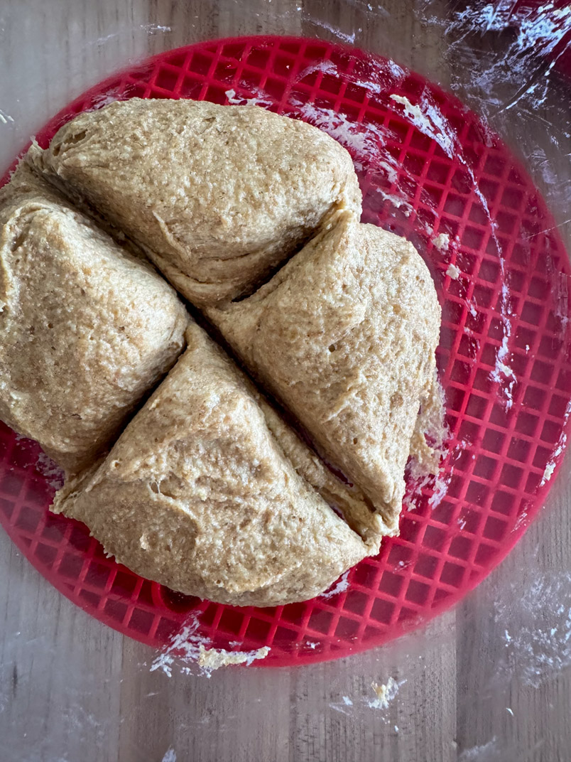 Divide einkorn wheat bread dough into quarters to make flatbread rounds