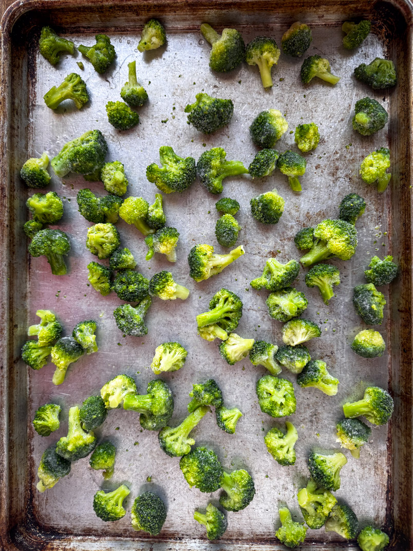 half sheet of small frozen broccoli florets ready for roasting
