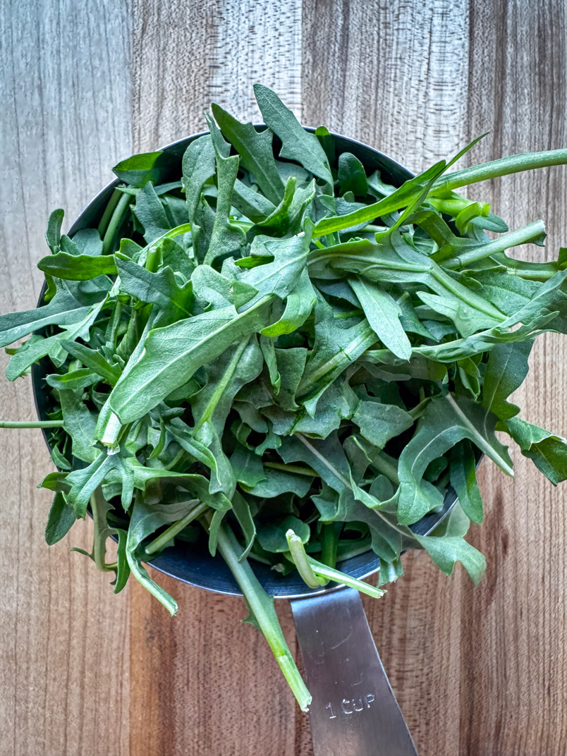 baby arugula packed tight in a one cup measuring cup