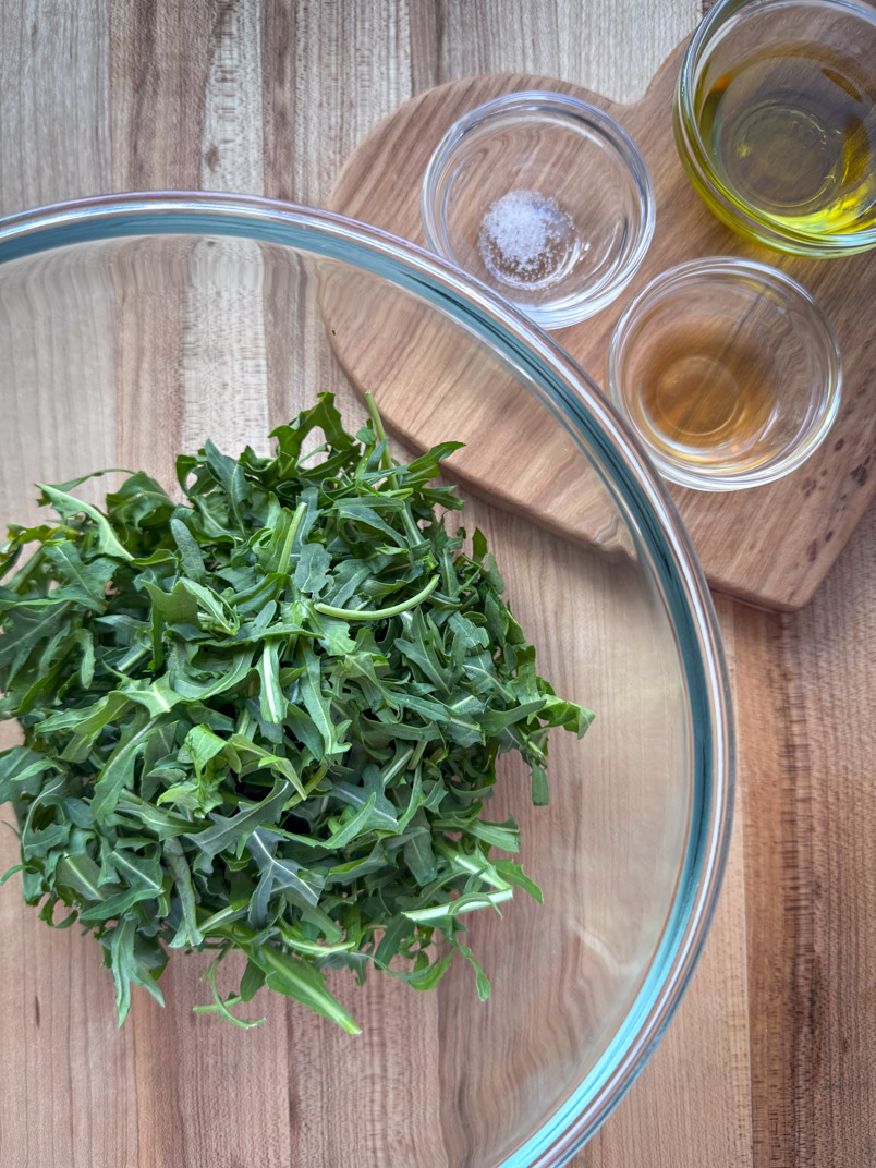 arugula greens in a serving bowl ready for making an arugula, broccoli, and beet salad